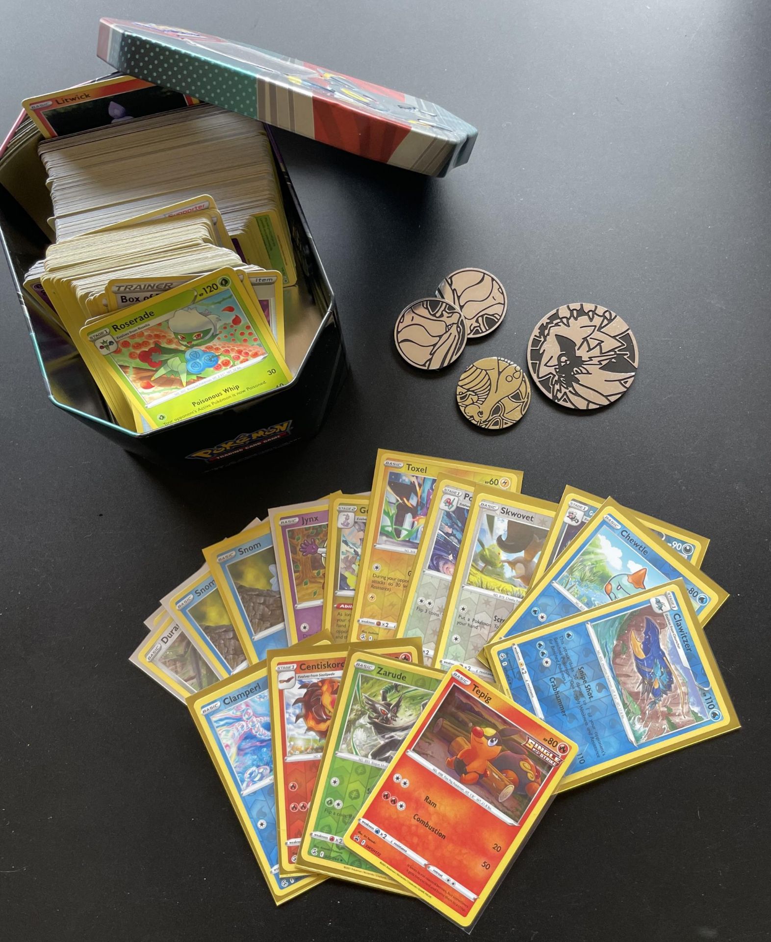 A TIN OF ASSORTED POKEMON CARDS, HOLOS, TOKENS ETC