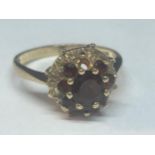 A 9 CARAT GOLD RING WITH EIGHT GARNETS IN A FLOWER DESIGN (ONE OUTER MISSING) SIZE M