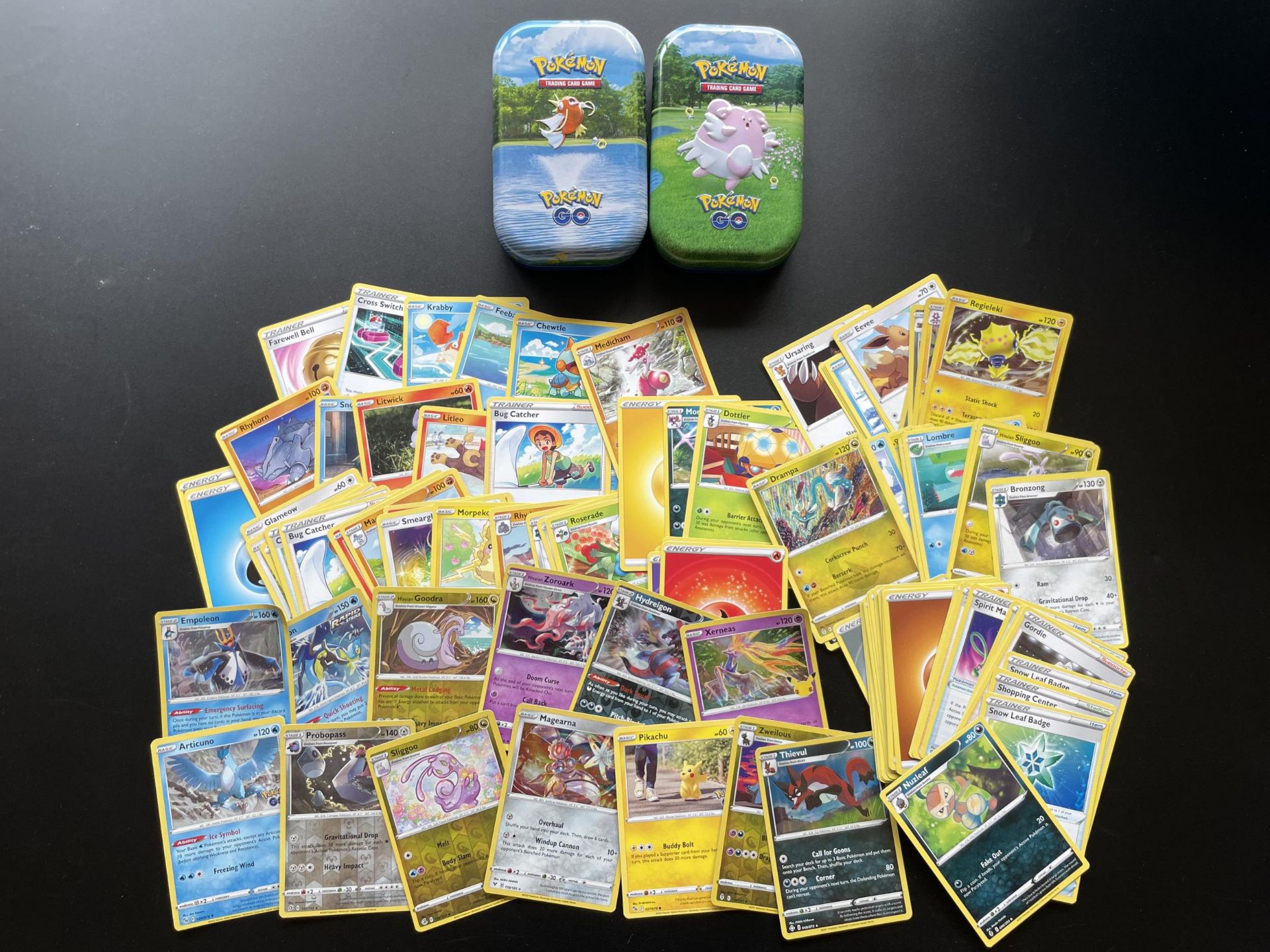 TWO TINS OF ASSORTED POKEMON CARDS, HOLOS ETC