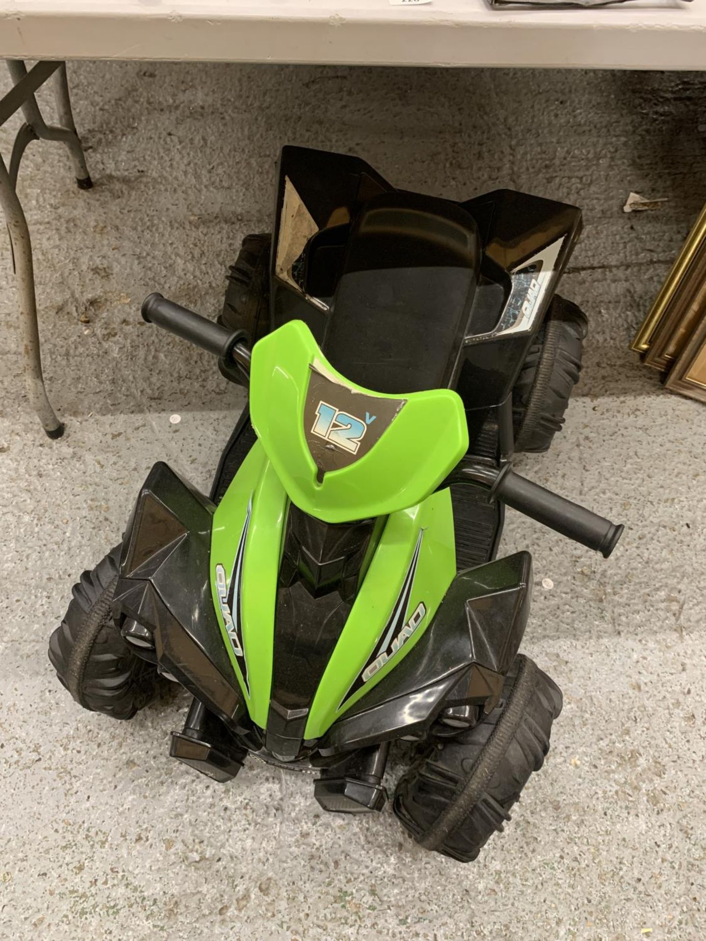 A CHILDREN'S ELECTRIC QUAD BIKE WITH CHARGER - VENDOR STATES IN WORKING ORDER AND VERY LITTLE USE,