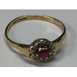 A 9 CARAT GOLD RING WITH CENTRE RUBY SURROUNDED BY DIAMONDS SIZE L/M