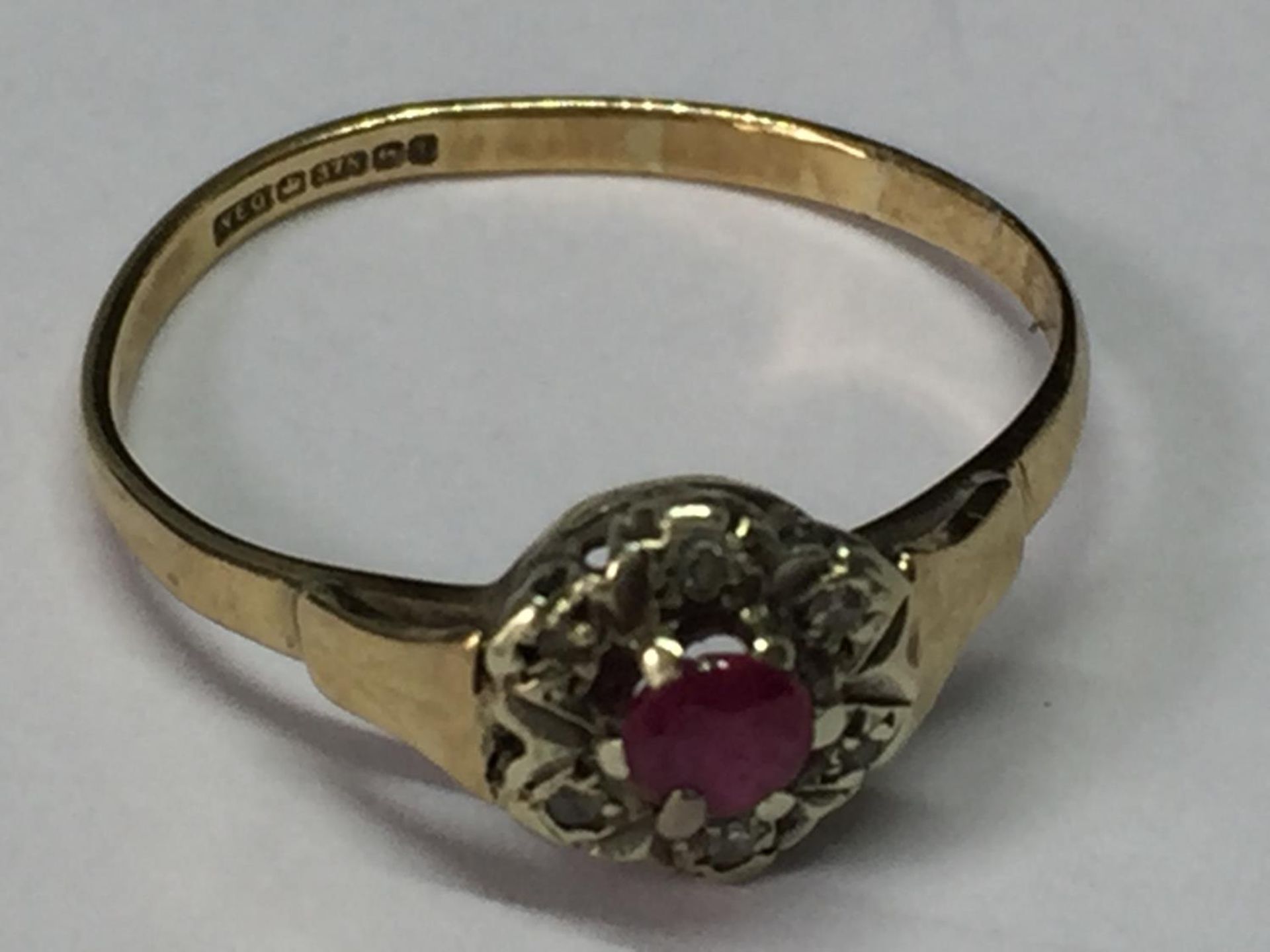 A 9 CARAT GOLD RING WITH CENTRE RUBY SURROUNDED BY DIAMONDS SIZE L/M