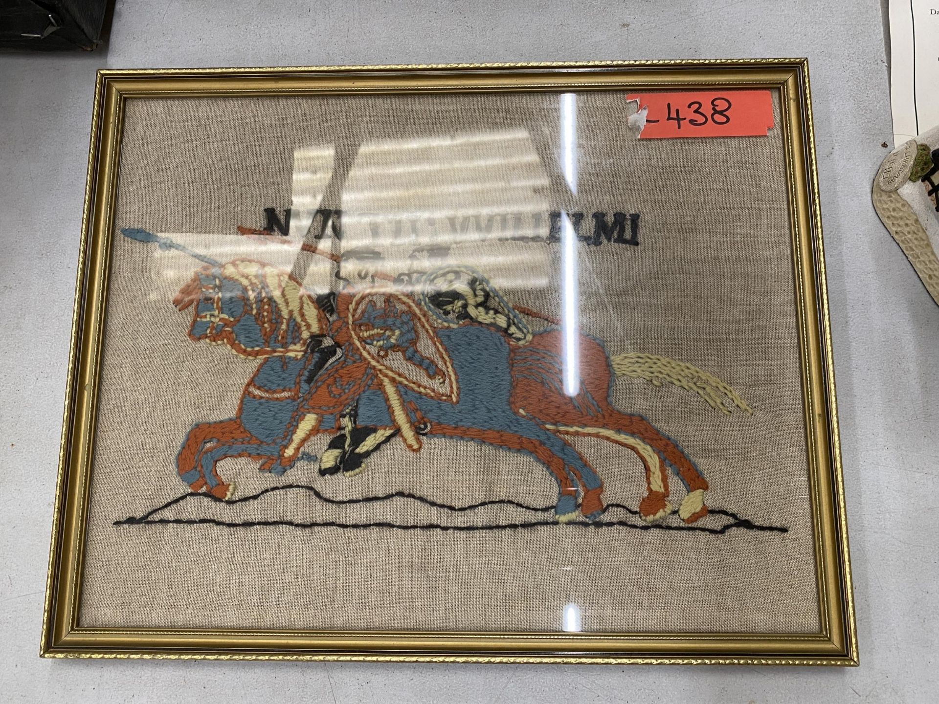 A FRAMED WOOLWORK TAPESTRY OF JOUSTING HORSES