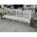 A THREE SEATER WOODEN SLATTED GARDEN BENCH WITH SCROLL METAL ENDS AND MIDDLE SUPPORT