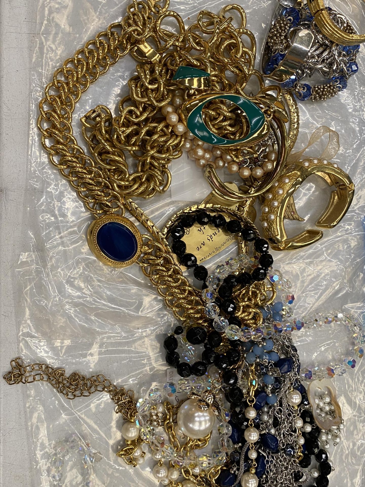 A QUANTITY OF WHITE AND YELLOW METAL COSTUME JEWELLERY TO INCLUDE BANGLES AND NECKLACES