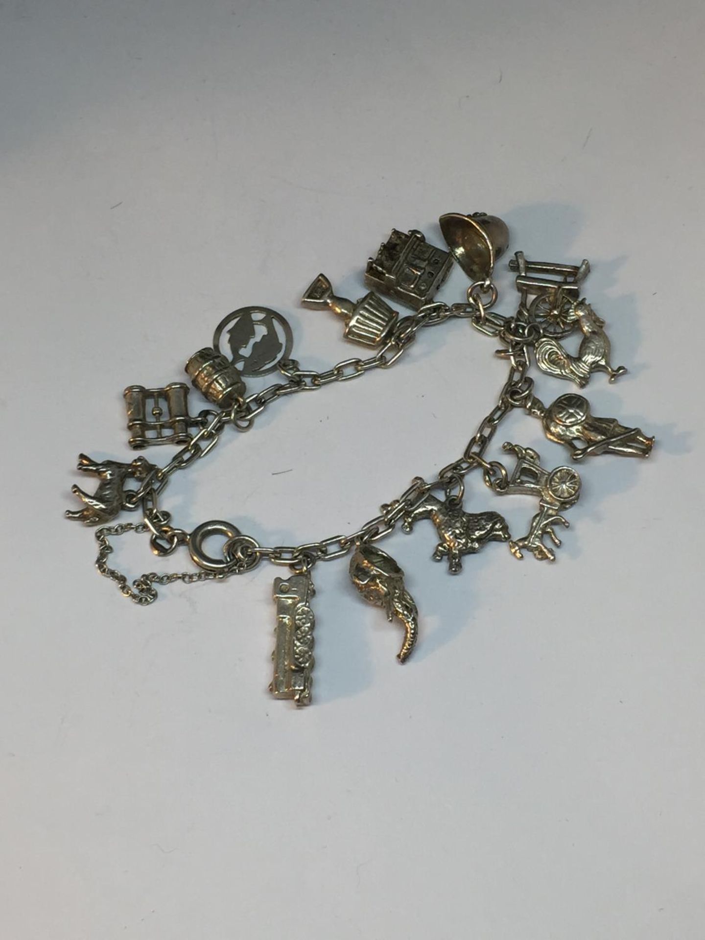 A SILVER CHARM BRACELET WITH FOURTEEN CHARMS