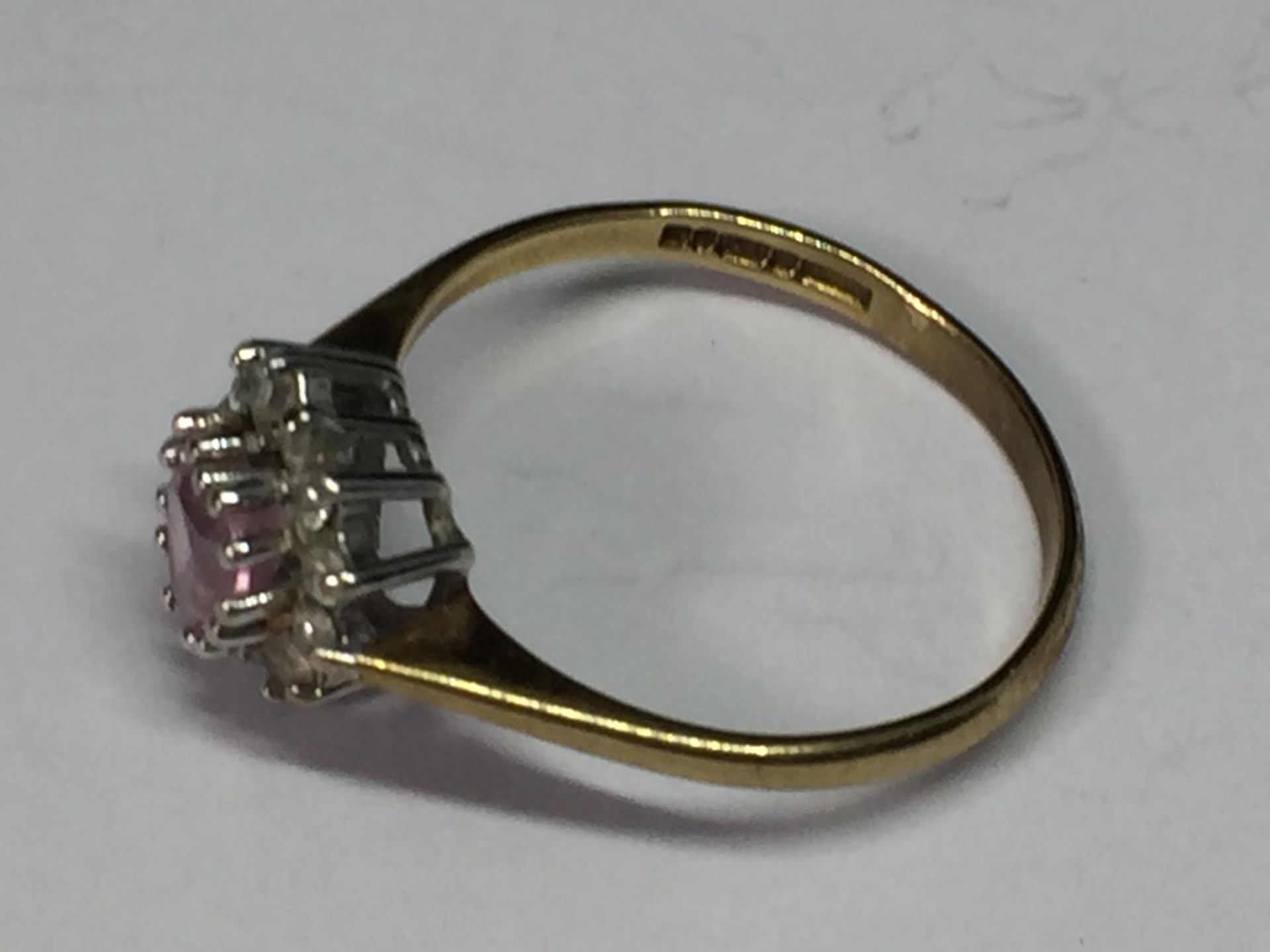 A 9 CARAT GOLD RING WITH A PINK HEART CENTRE STONE SURROUNDED BY CUBIC ZIRCONIAS SIZE O - Bild 2 aus 3