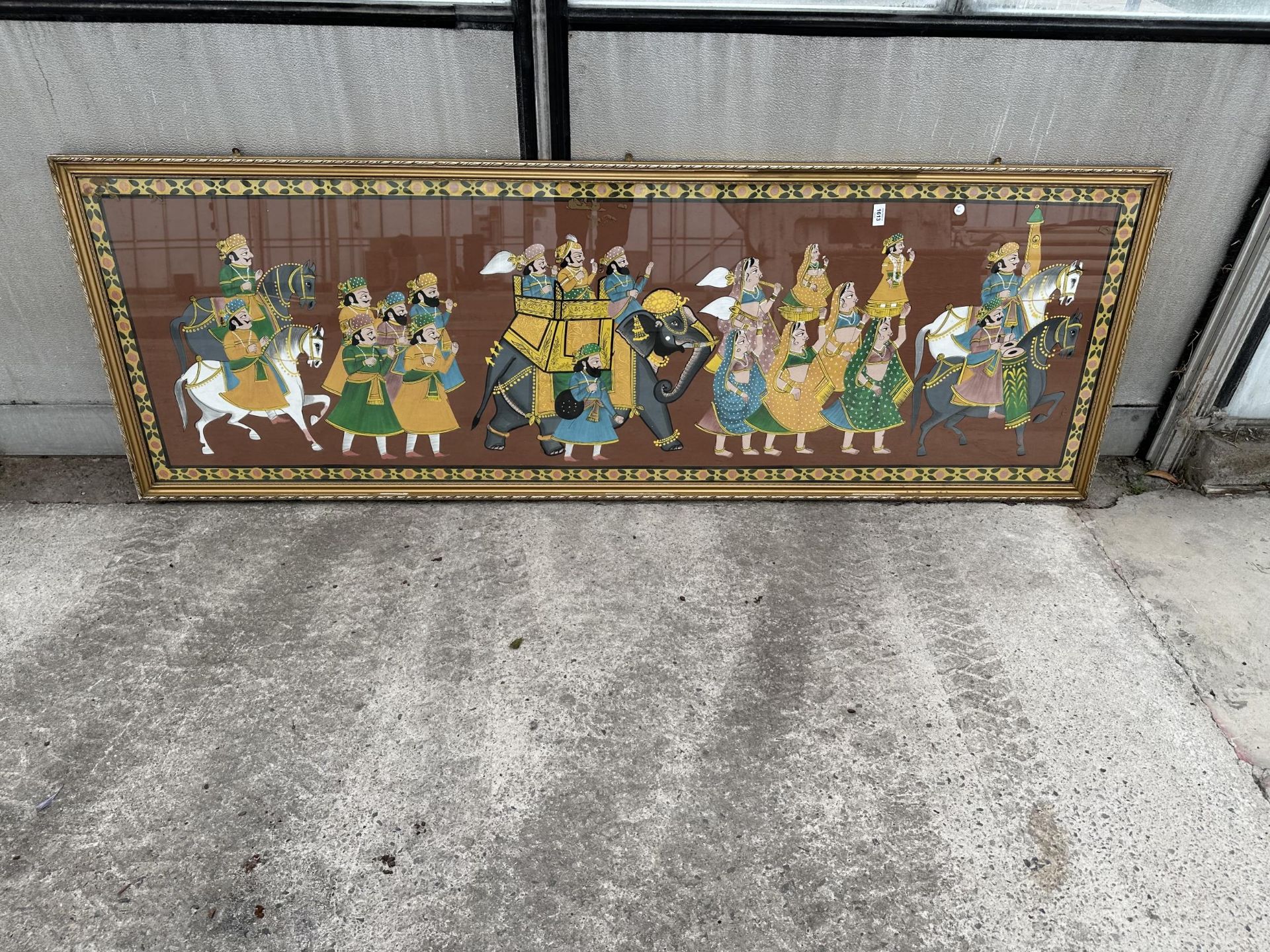 A LARGE GILT FRAMED PRINT OF AN INDIAN RELIGIOUS SCENE