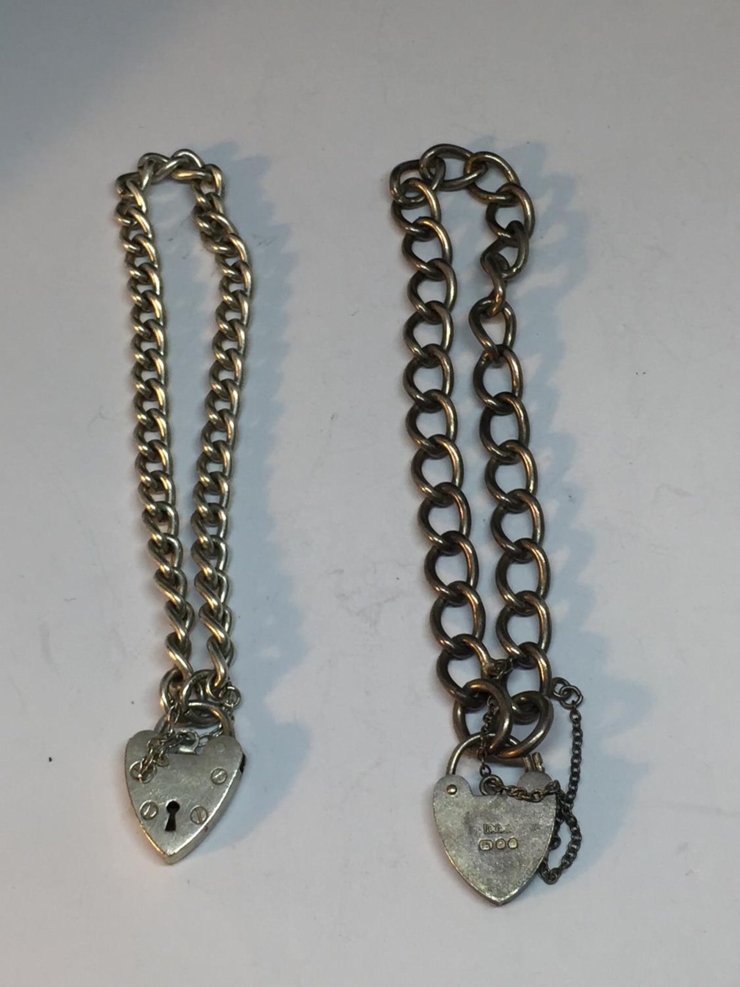 TWO SILVER BRACELETS WITH HEART PADLOCKS