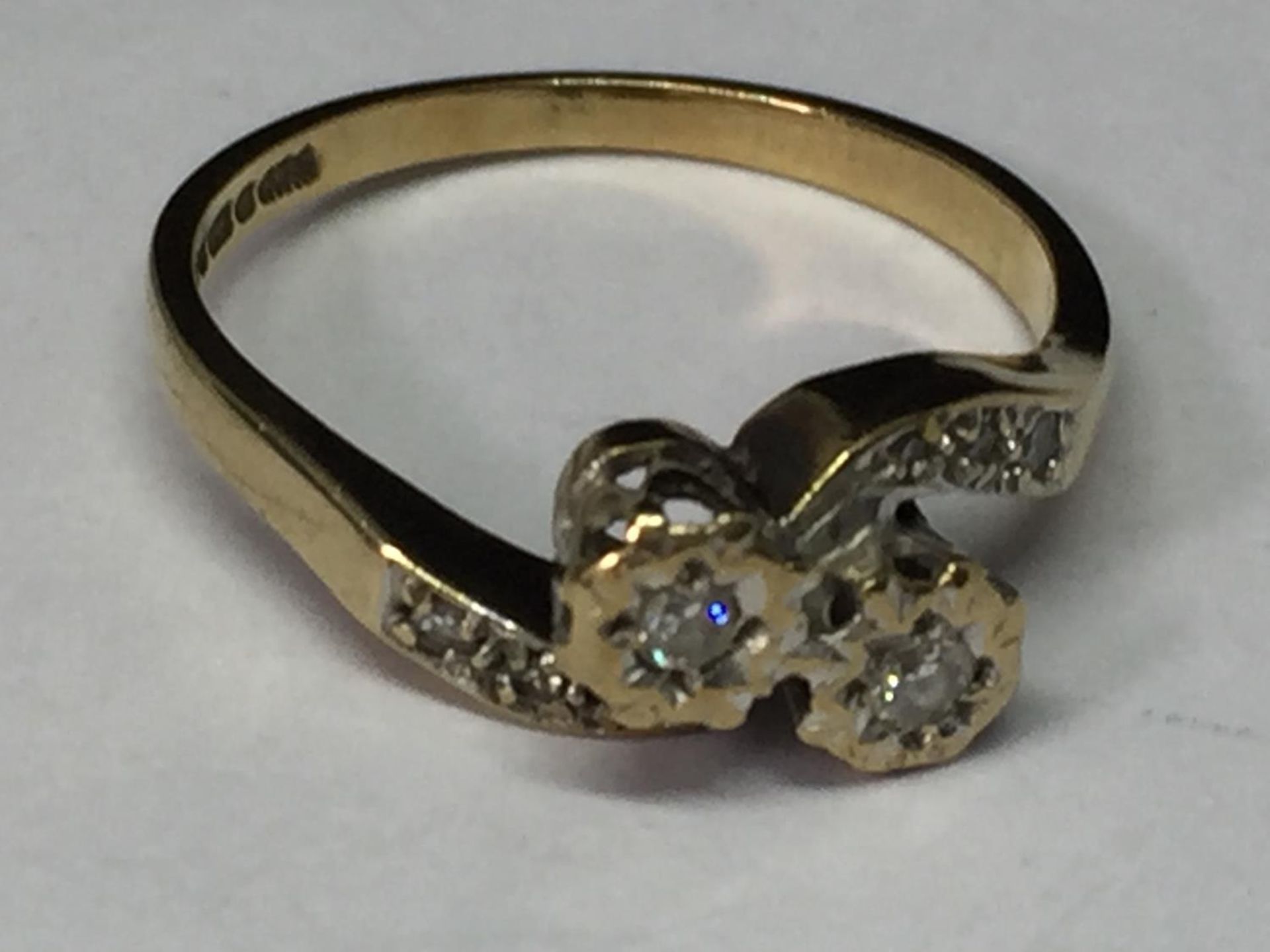 A 9 CARAT GOLD RING WITH DIAMONDS ON A TWIST DESIGN SIZE M