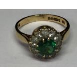 A 9 CARAT GOLD RING WITH A CENTRE EMERALD SURROUNDED BY WHITE SAPPHIRES IN A FLOWER DESIGN SIZE I