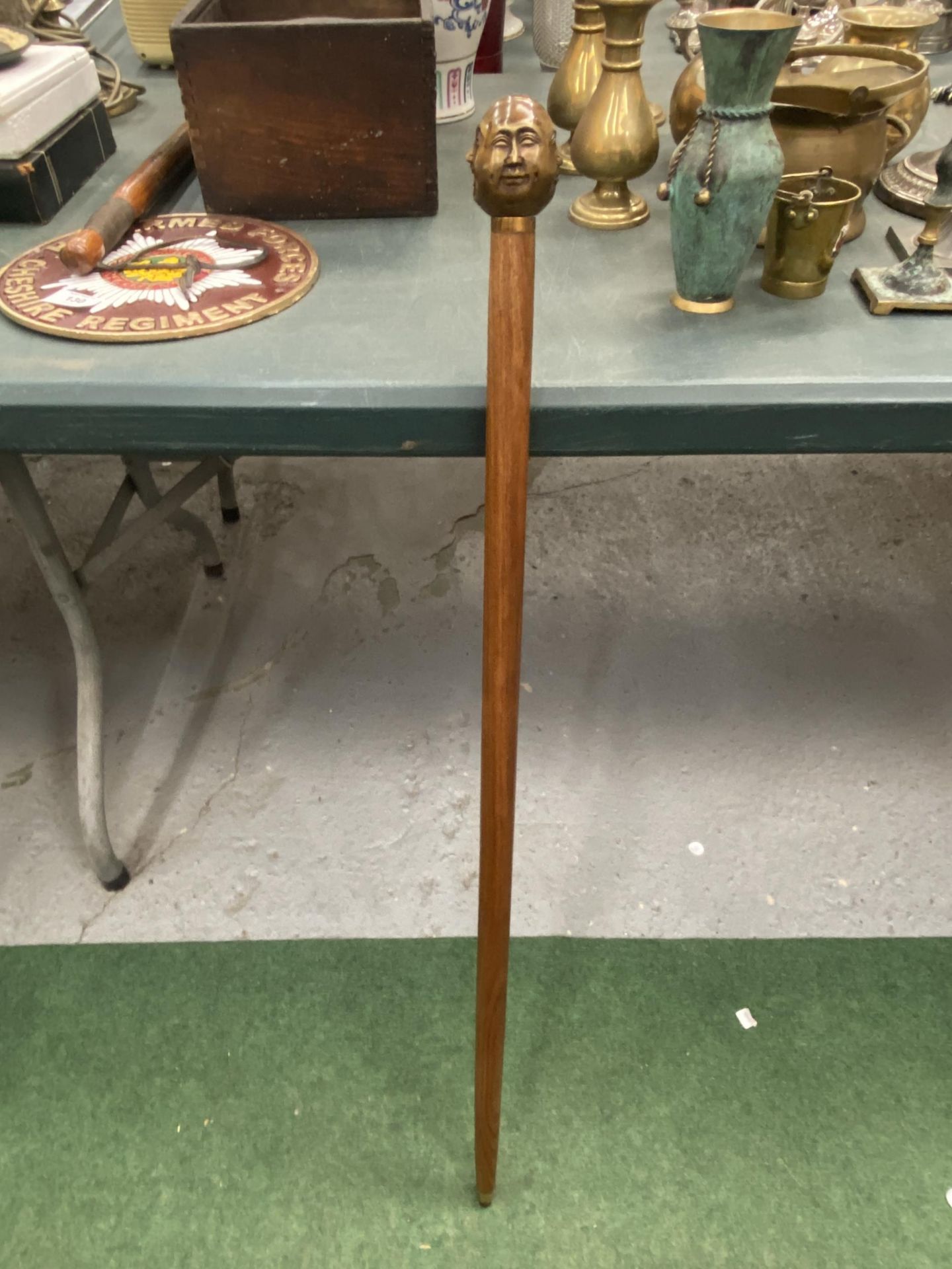 A WALKING STICK WITH A BRASS FOUR FACED BUDDAH HANDLE