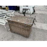 A LARGE WICKER LOG BASKET WITH HINGED LID AND METAL BANDING