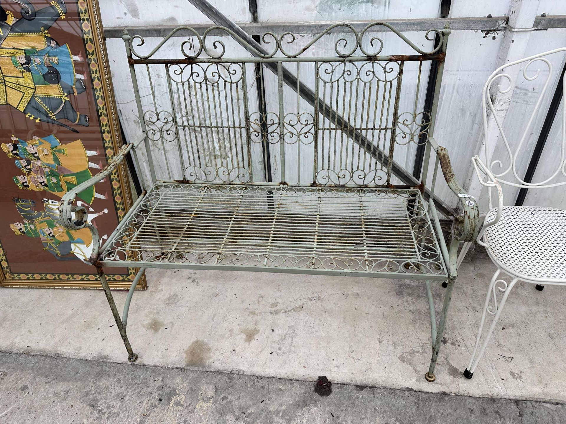 A DECORATIVE TURNED METAL FOLDING TWO SEATER GARDEN BENCH