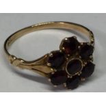 A 9 CARAT GOLD RING WITH SEVEN GARNETS IN A FLOWER DESIGN SIZE L/M