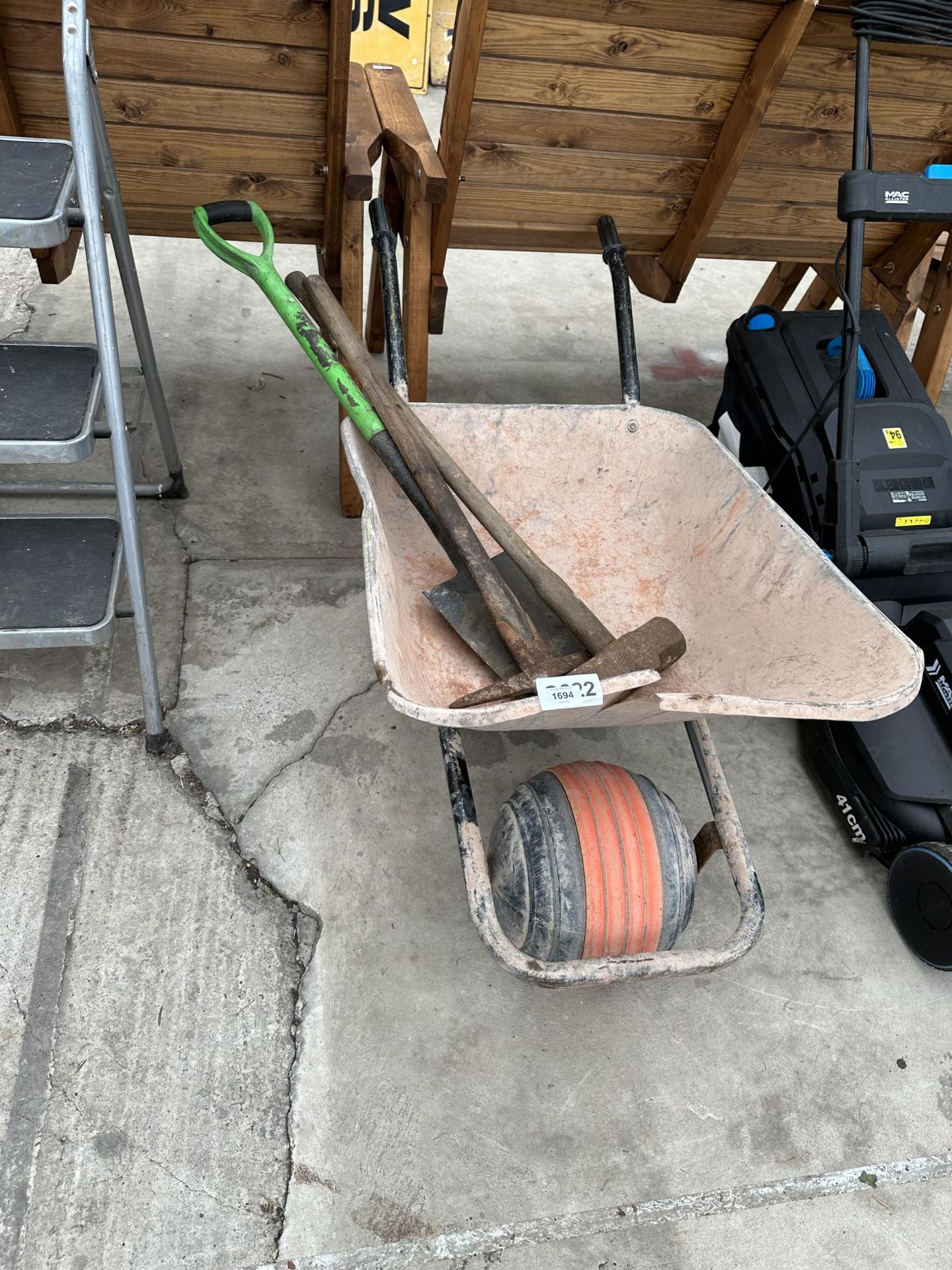 A METAL WHEEL BARROW AND TOOLS TO INCLUDE A SLEDGE HAMMER AND A PICK AXE ETC