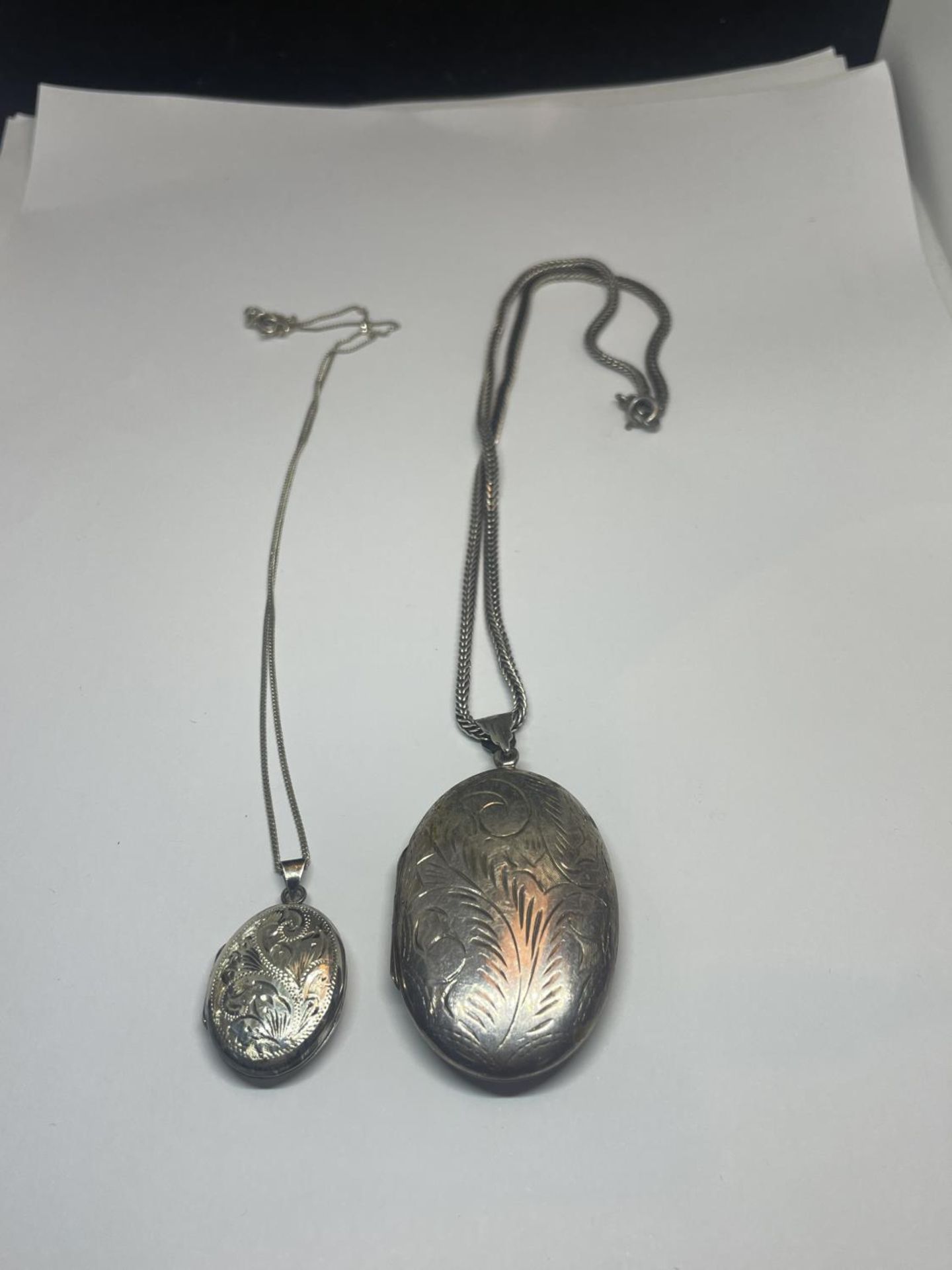 TWO SILVER LOCKETS ON CHAINS