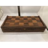 A VINTAGE HARDWOOD CHESS BOARD WITH CARVED WOODEN PIECES