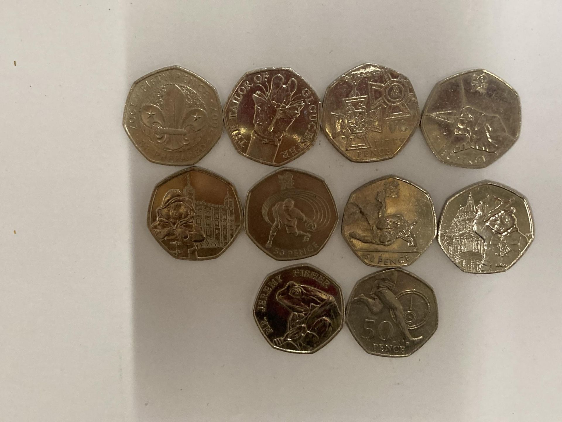 TEN VARIOUS COLLECTABLE FIFTY PENCE PIECES TO INCLUDE PADDINGTON BEAR, JEREMY FISHER, OLYMPICS ETC