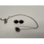 A SILVER AND PURPLE STONE PENDANT WITH MATCHING EARRINGS