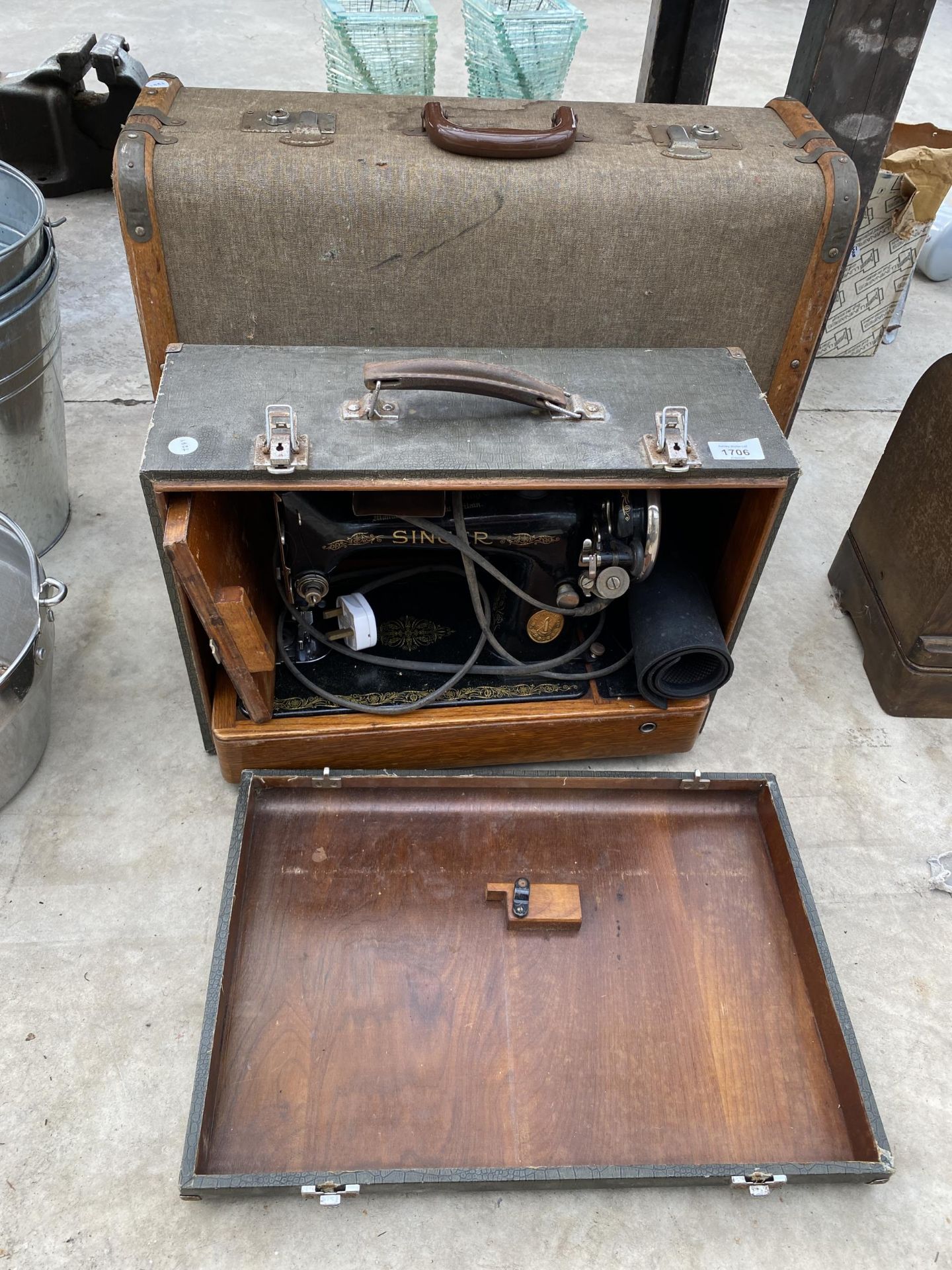 A CASED VINTAGE SINGER SEWING MACHINE AND A VINTAGE SUITCASE