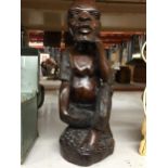 A HEAVY WOODEN CARVED TRIBAL STYLE FIGURE, HEIGHT 34CM