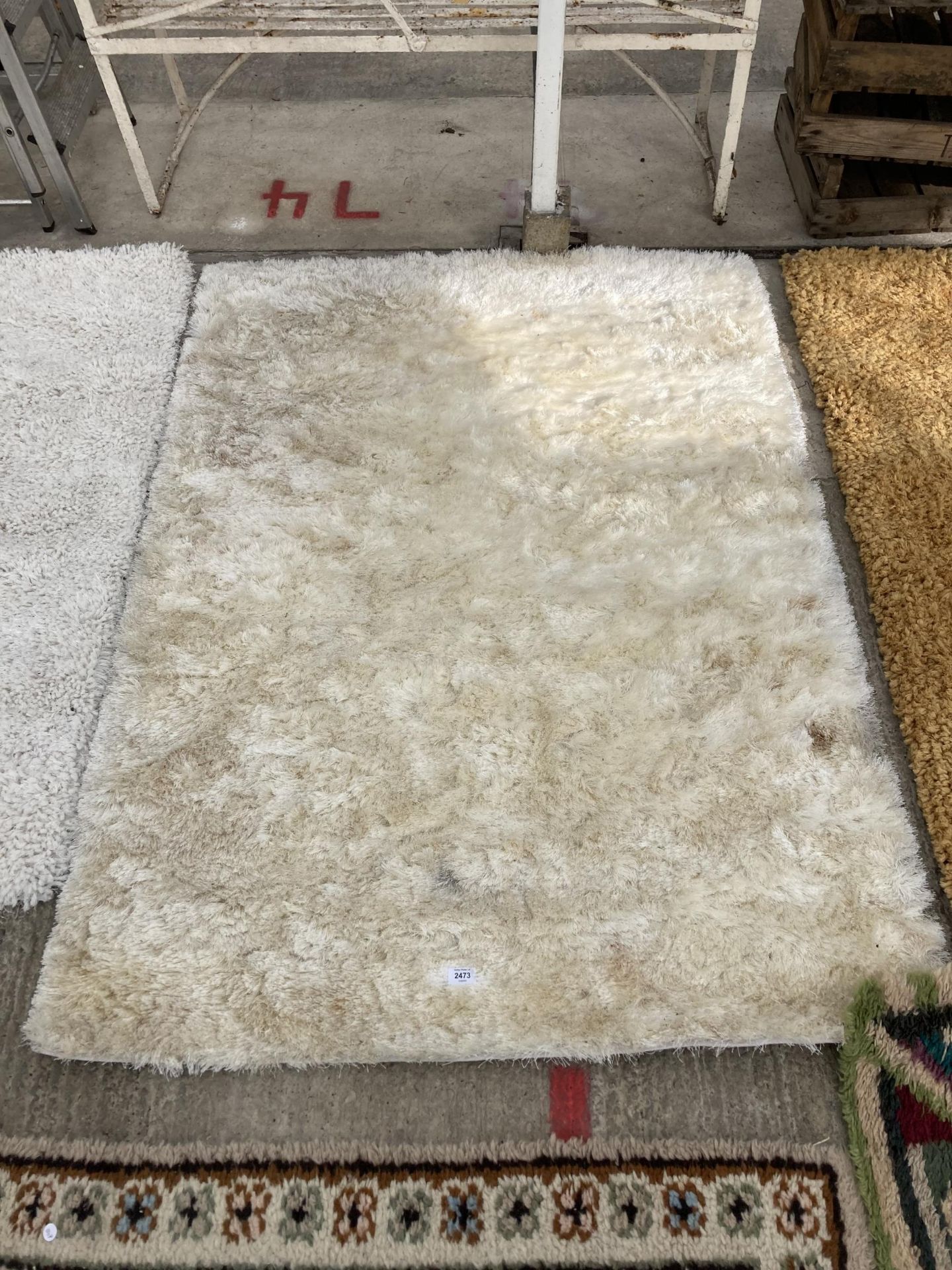 A MODERN CREAM SHAGGY RUG