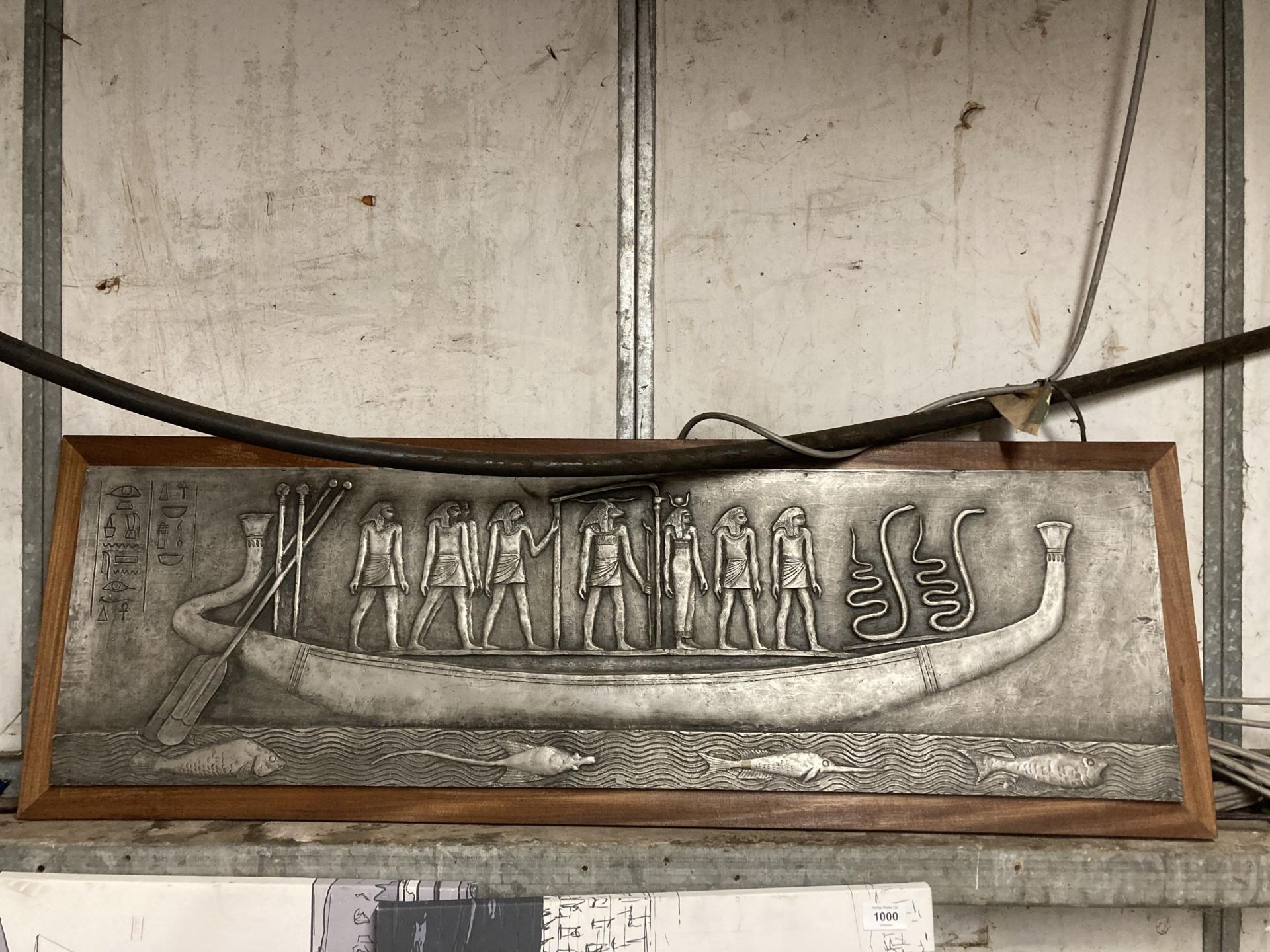 AN EGYPTIAN EMBOSSED FIBREGLASS PLAQUE DEPICTING PHARAOH ON HIS BARGE, 30 X 104 CM, FRAMED