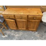 A MODERN PINE SIDEBOARD ENCLOSING THREE DRAWERS AND THREE CUPBOARDS, 47" WIDE