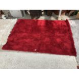 A MODERN RED SHAGGY RUG