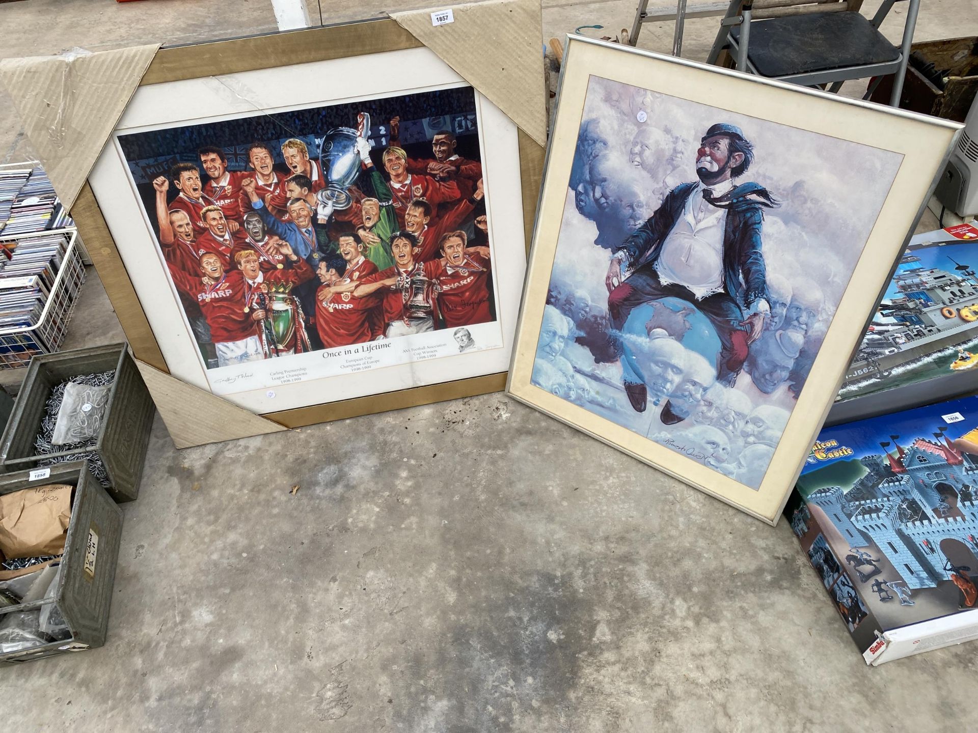 A FRAMED PRINT OF A CLOWN AND A FRAMED PRINT OF THE MANCHESTER UNITED 1999 TREBLE WINNERS