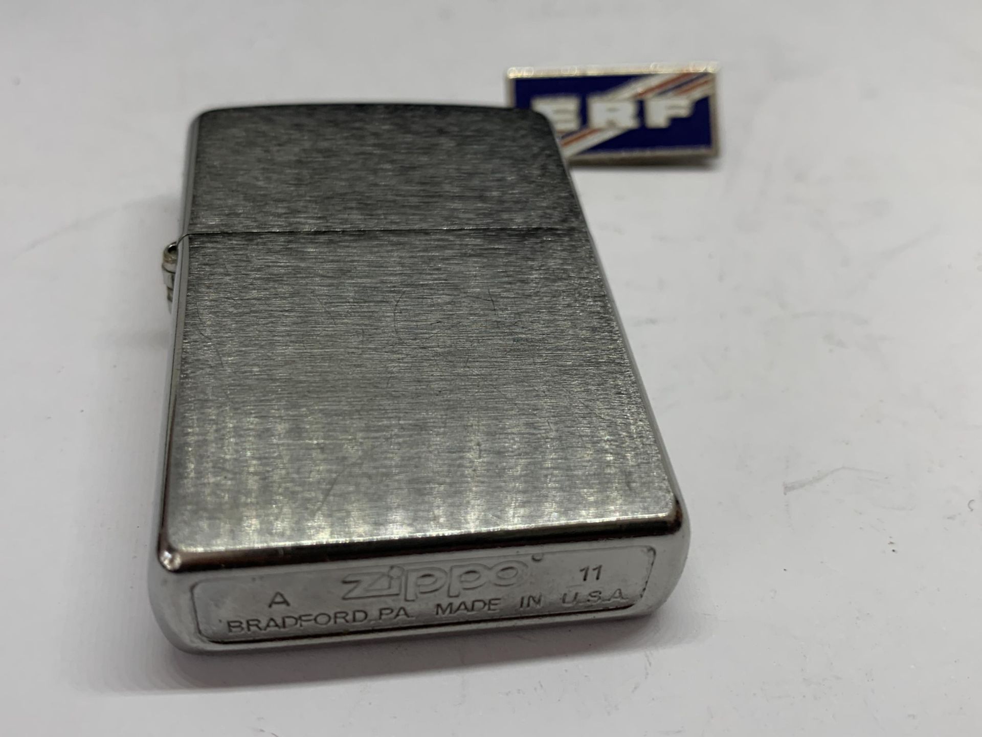 A MADE IN USA ZIPPO LIGHTER AND AN ENAMEL ERF BADGE - Image 3 of 3