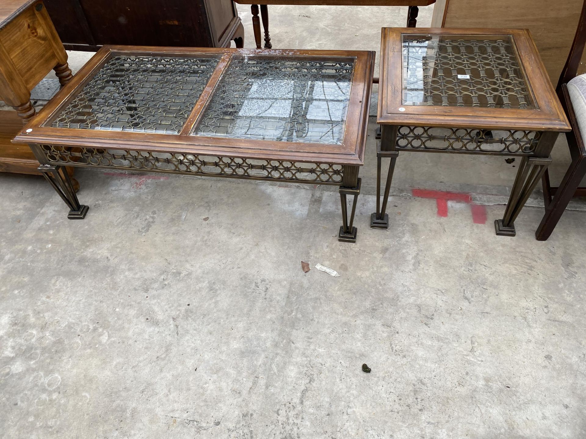 A COFFEE TABLE WITH GLASS TOP HAVING INSERTED METALWARE DECORATION AND A MATCHING LAMP TABLE