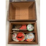 A WOODEN BOX CONTAINING ASSORTED BADGES, CAR BADGES ETC