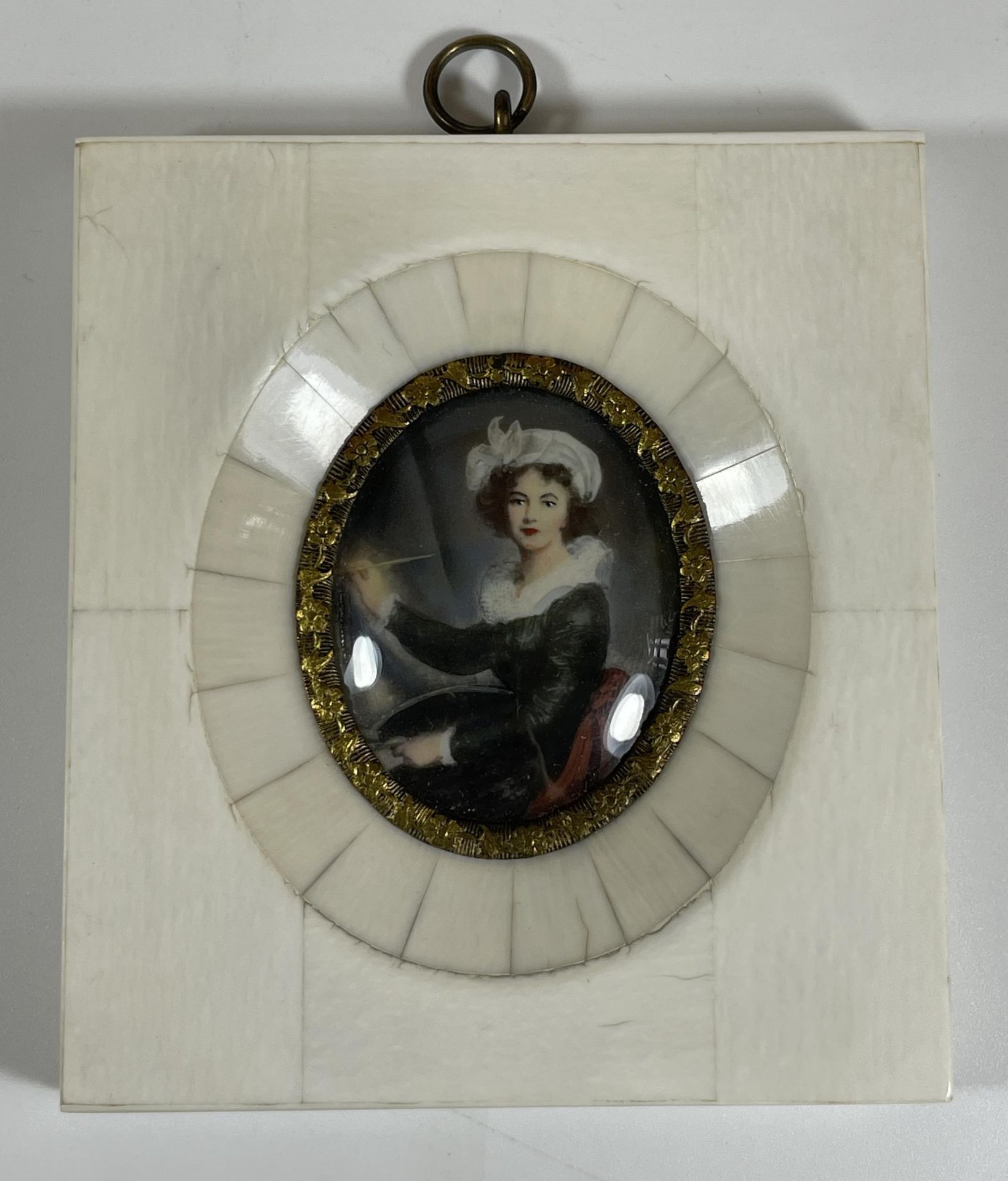 AN ANTIQUE PORTRAIT MINIATURE OF A LADY PAINTING WITH GILT BORDER