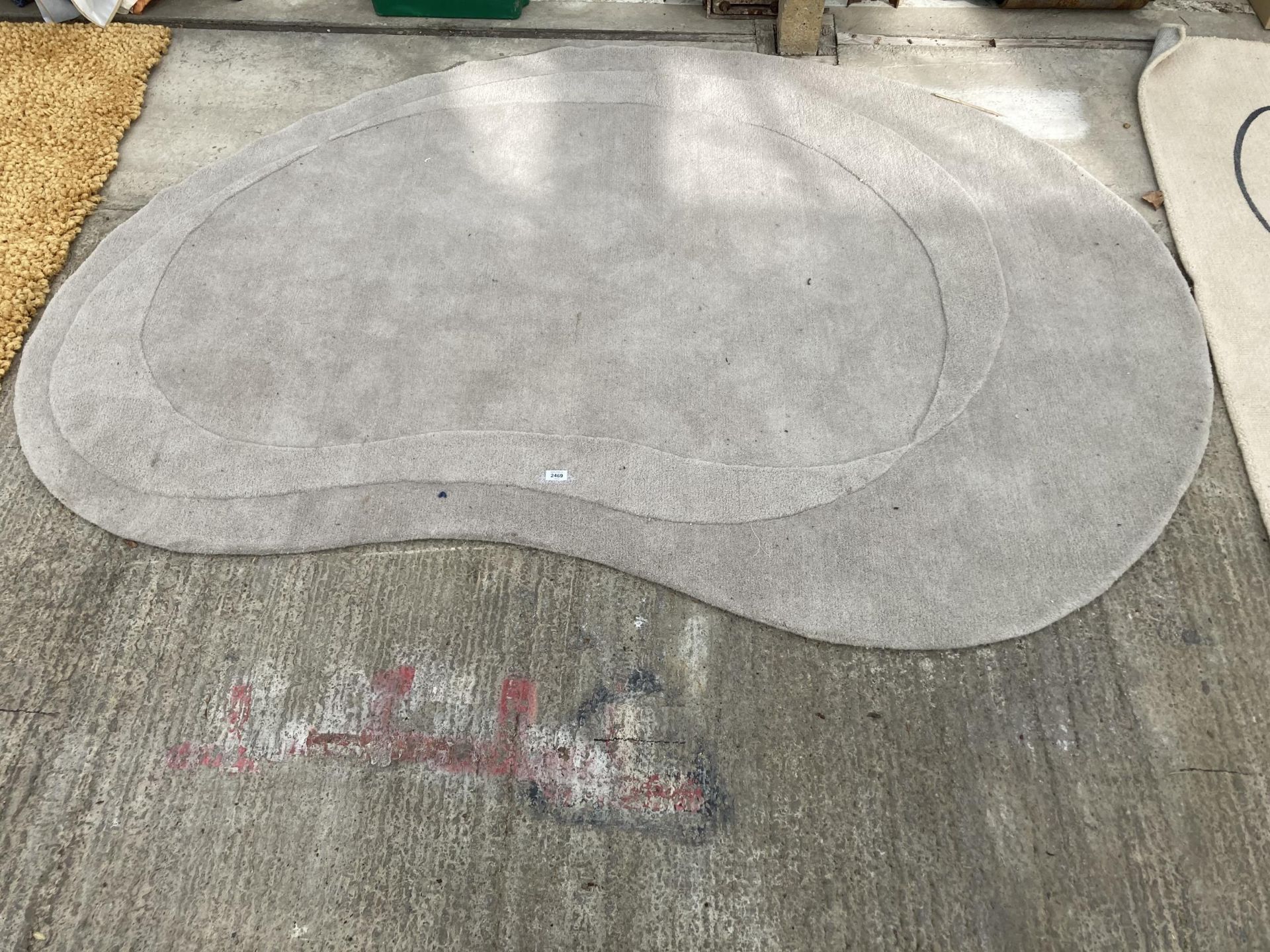 A KIDNEY SHAPED CREAM RUG