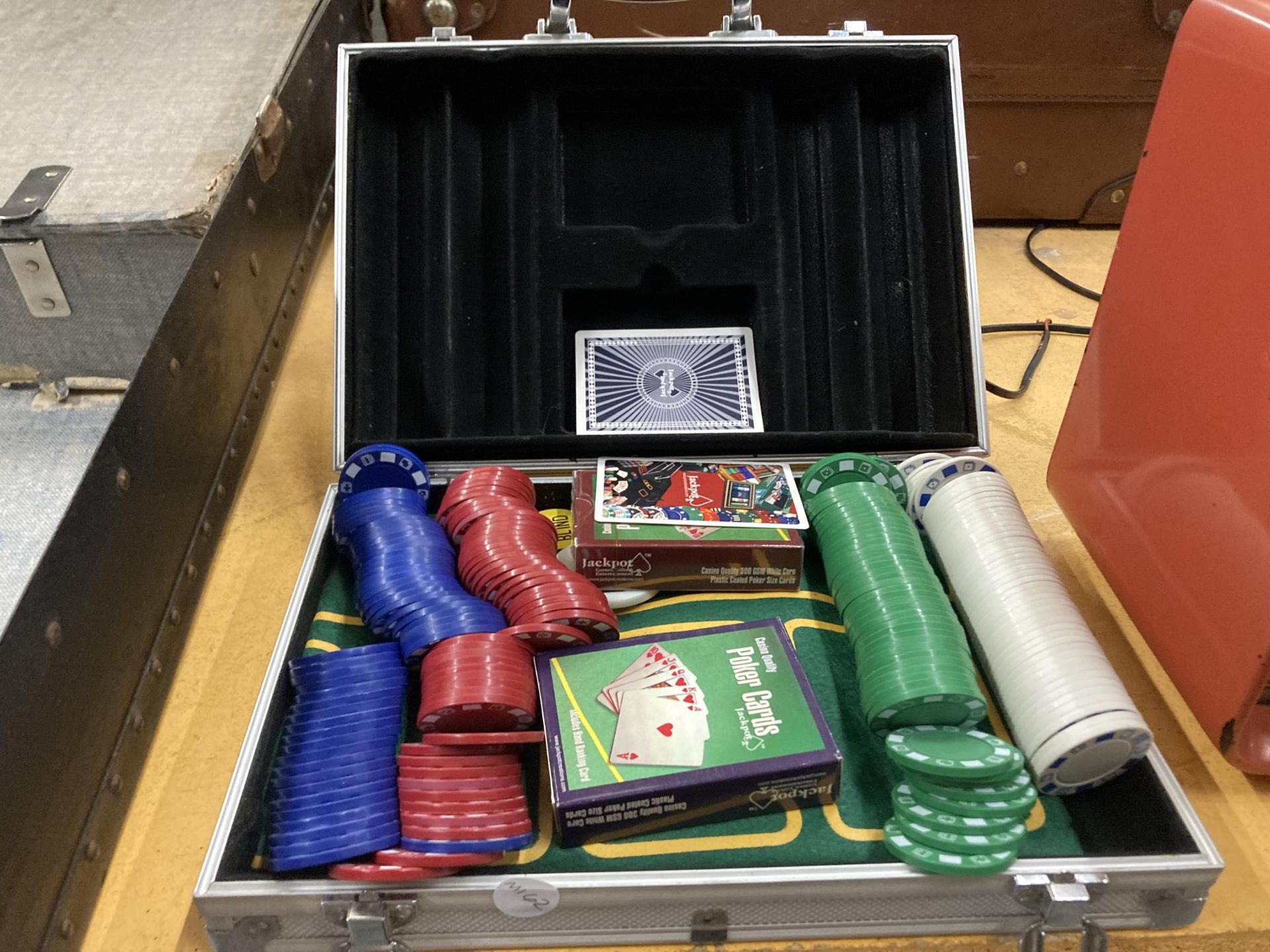 A POKER SET WITH CHIPS, MAT AND PLAYING CARDS IN A CASE