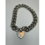 A HEAVY SILVER WRIST CHAIN WITH HEART PADLOCK
