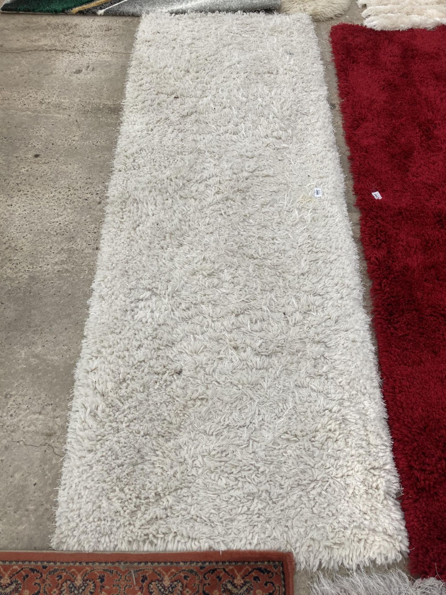 A MODERN CREAM SHAGGY RUG