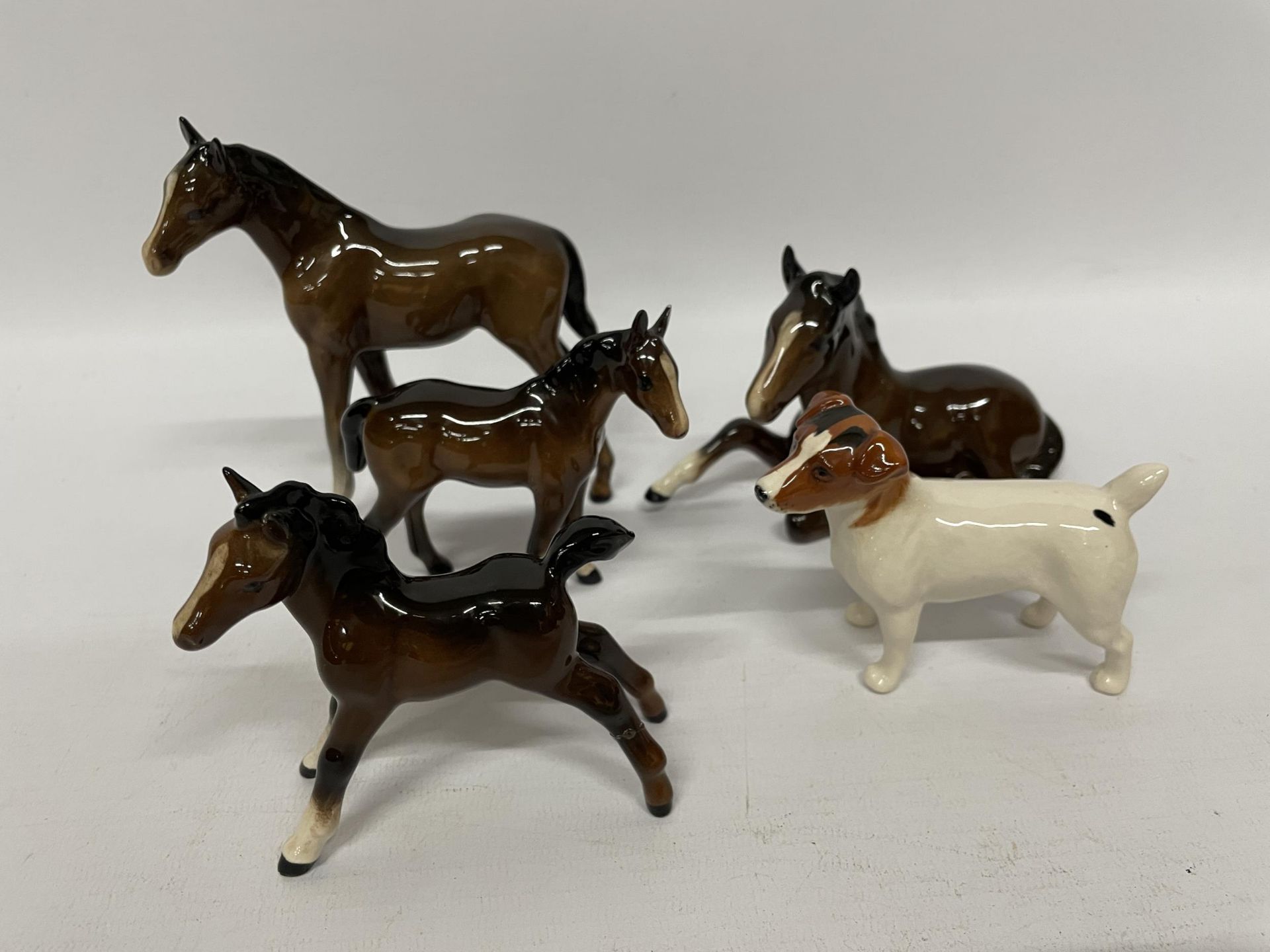 FIVE BESWICK GLOSS ANIMAL MODELS - FOUR PONIES AND A JACK RUSSELL DOG