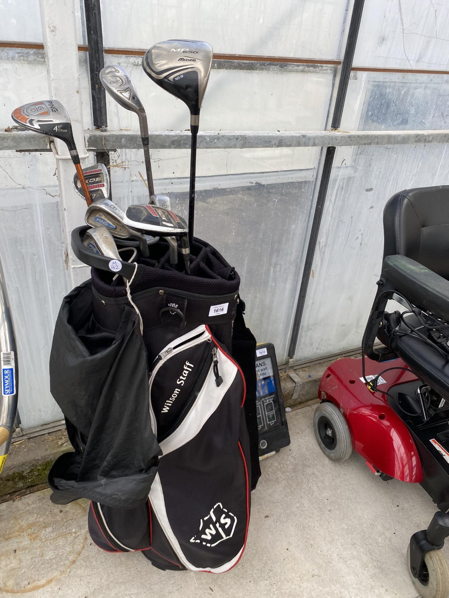 A WILSON STAFF GOLF BAG WITH AN ASSORTMENT OF GOLF CLUBS TO INCLUDE PING ETC