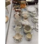 A MIXED GROUP OF CERAMICS TO INCLUDE VINTAGE COW CREAMER, CUPS, SAUCERS, NOVELTY TEAPOTS ETC
