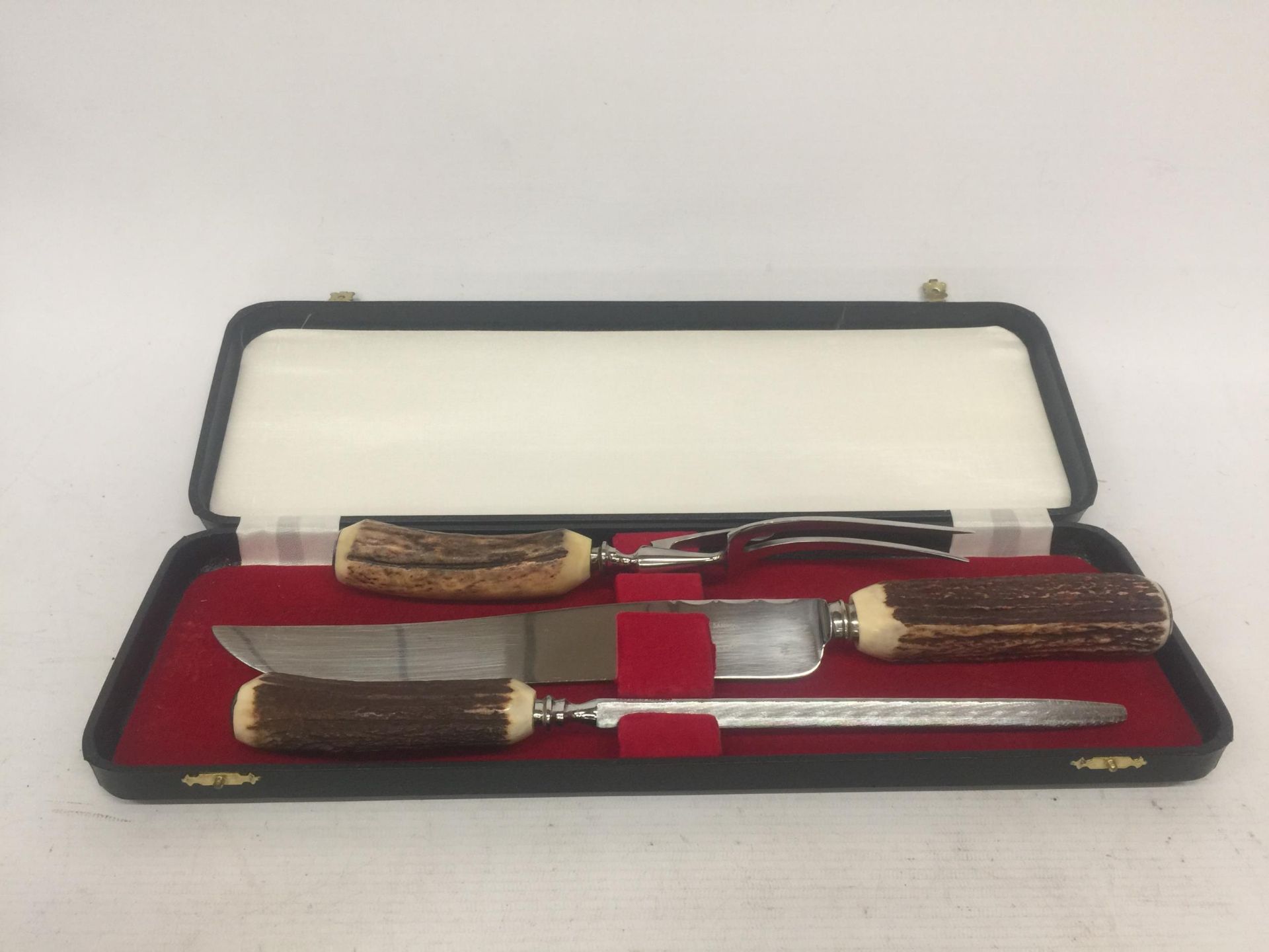 A BRIAN SAMPSON ANTLER HANDLED THREE PIECE STAINLESS STEEL CARVING SET IN A PRESENTATION BOX