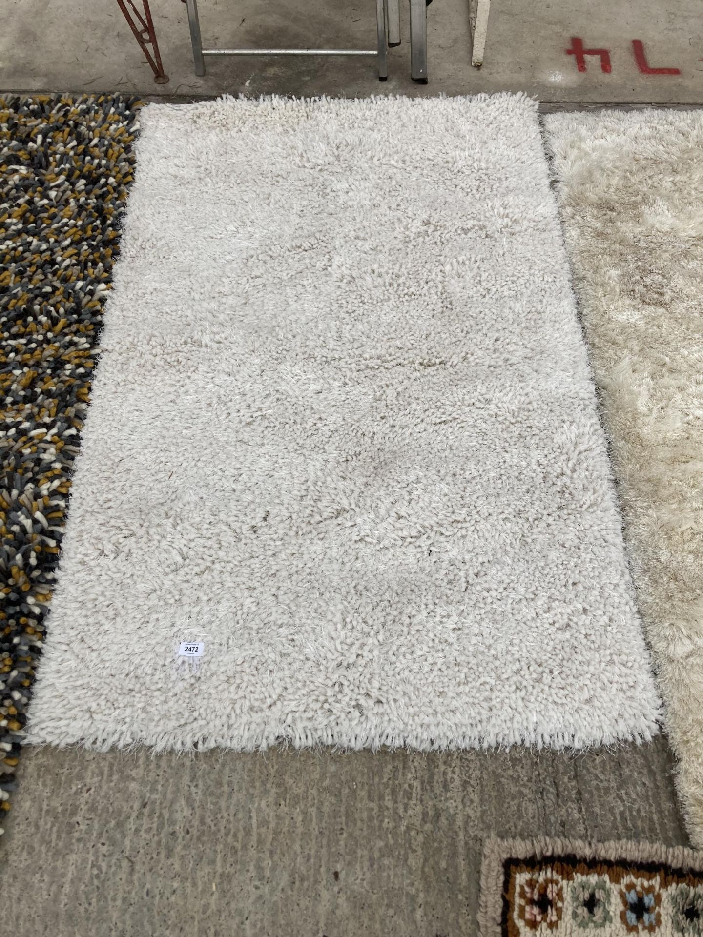 A MODERN CREAM SHAGGY RUG