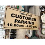 A WOODEN 'TIMBER & TOOLS CUSTOMER PARKING' SIGN