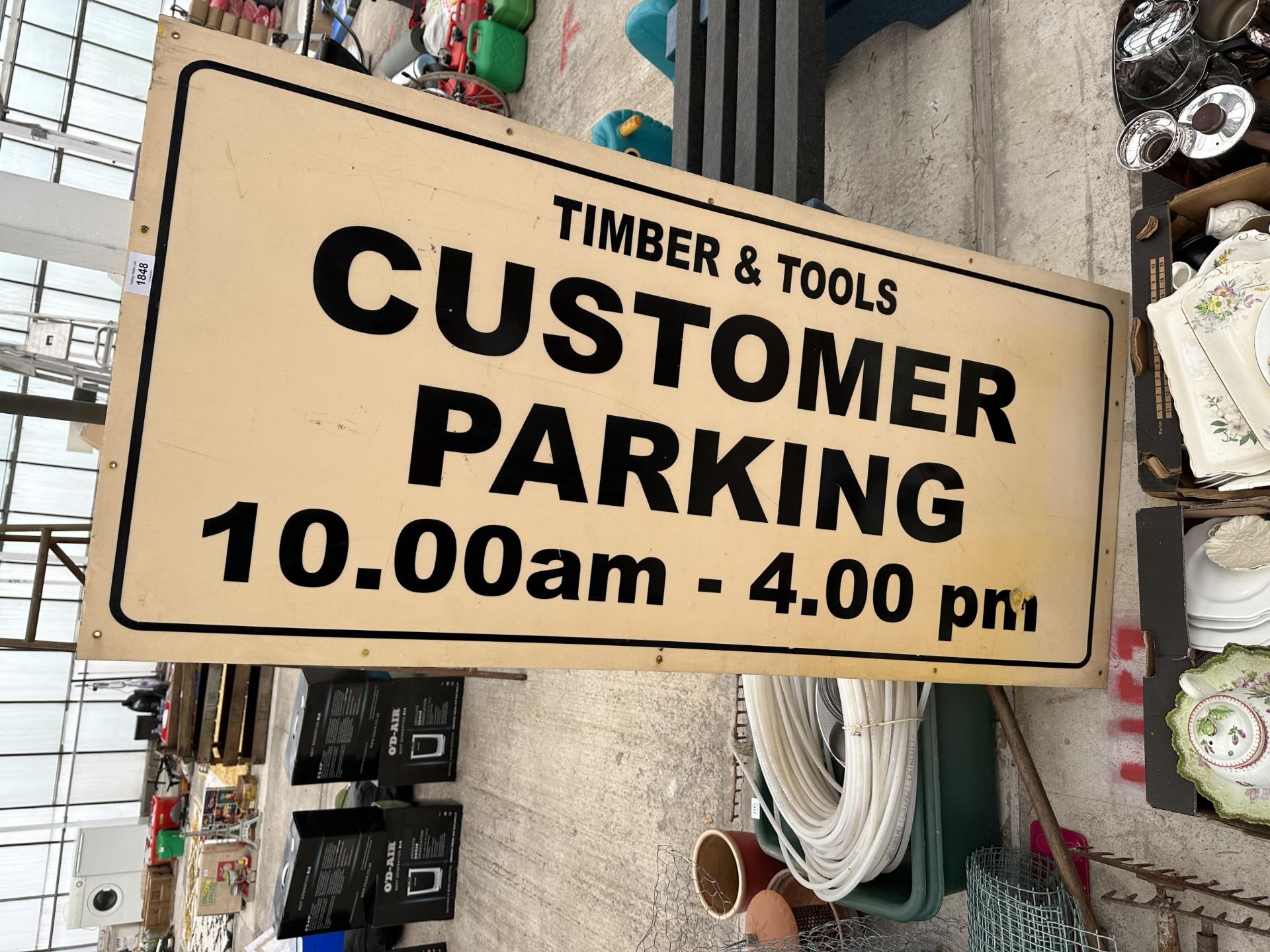 A WOODEN 'TIMBER & TOOLS CUSTOMER PARKING' SIGN