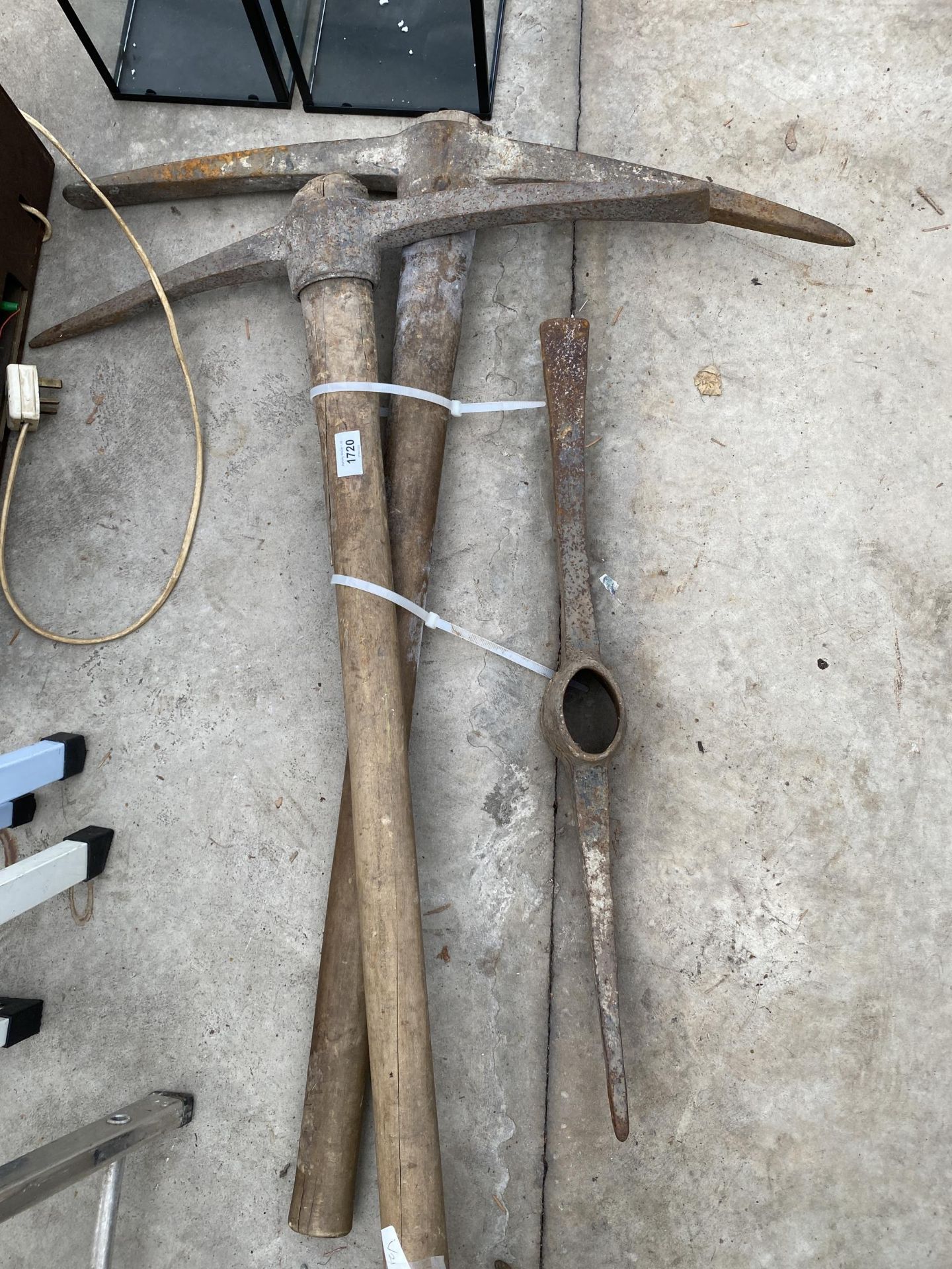TWO WOODEN HANDLED PICK AXES AND A FURTHER PICK AXE HEAD
