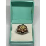 A SILVER DESIGNER RING WITH A COPPER COLOURED FLOWER DESIGN SIZE N IN A PRESENTATION BOX