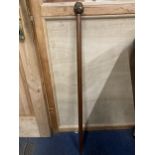 A WALKING STICK WITH A BRASS FOUR FACED BUDDAH HANDLE