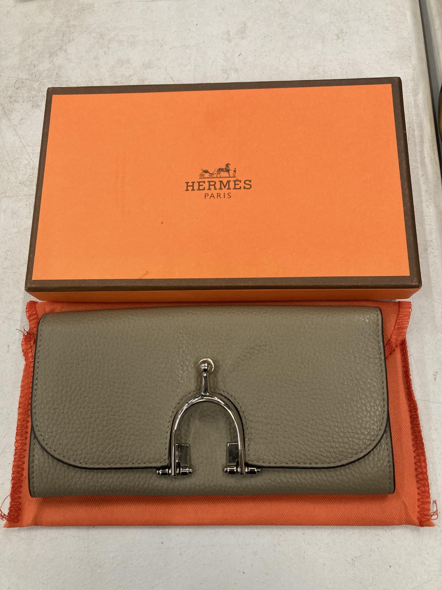 A TAUPE COLOURED PURSE MARKED 'HERMES' WITH DUST COVER AND BOX